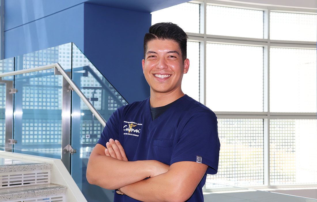 Medical Assistant student Isaias Fajardo stands confidently by the staircase
